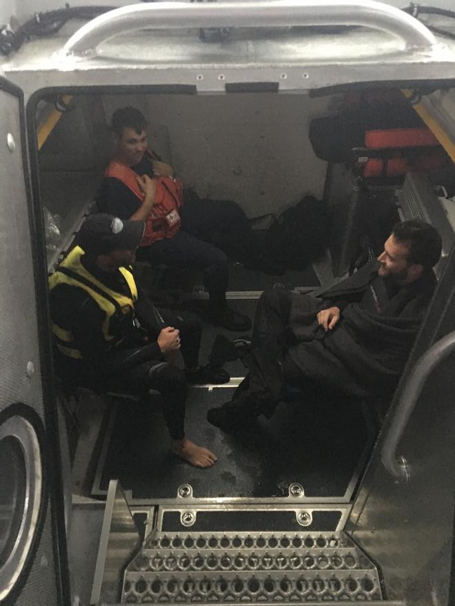 A Coast Guard Station Castle Hill boat crew member sits with the survivors from a capsized catamaran off Jamestown, Rhode Island, Saturday, Sept. 30, 2017. The boat crew brought the survivors and their vessel back to Dutch Harbor.  © U.S. Coast Guard photo by Petty Officer 2nd Class