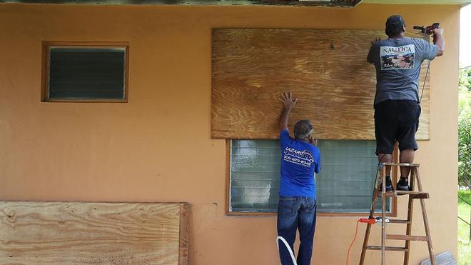 People put up shutters as they prepare a family members house for Hurricane Irma on September 6, 2017 in Miami, Florida. It's still too early to know where the direct impact of the hurricane will take place but the state of Florida is in the area of possible landfall. © Joe Raedle / Getty Images