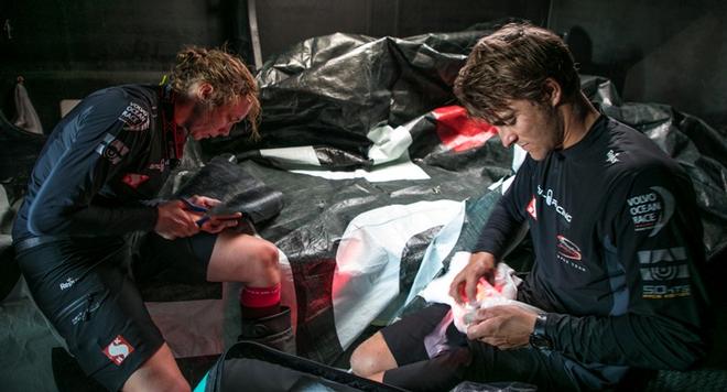 Leg 1, Day 2 – Alicante to Lisbon, onboard Sun Hung Kai/Scallywag. Australian sailor Alex Gough and Dutch Olympian Annemeike Bes repair a sail onboard in 20 knots of wind – Volvo Ocean Race ©  Jeremie Lecaudey / Volvo Ocean Race