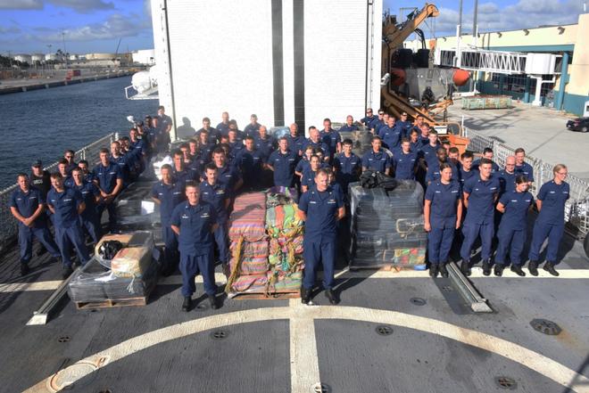 The crew of the Coast Guard Cutter Spencer stands next to approximately 10 tons of seized contraband prior to disposition at Port Everglades in Fort Lauderdale, Florida, Tuesday, Nov. 14, 2017. The fight against transnational organized crime networks in the Eastern Pacific requires unity of effort in all phases from detection, monitoring and interdictions, to prosecution. © Petty Officer Third Class Brandon Murray