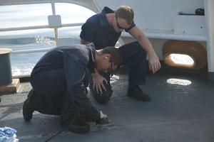 Seaman Gannon instructs a newly reported shipmate on the proper way to use power tools while removing rust spots from the deck of Coast Guard cutter Active on Oct. 11, 2017. Coast Guard cutter Active is homeported in Port Angeles, Washington. photo copyright Petty Officer 3rd Class Nicole J. Groll taken at  and featuring the  class