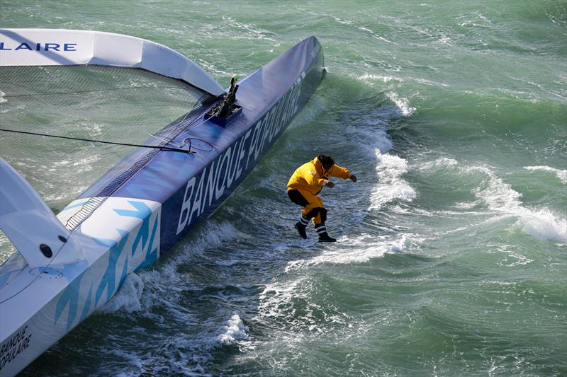 Support crew leap off Ultim Banque Populaire XI, before the start  of Transat Jacques Vabre in Le Havre, France, on October 29, 2023 photo copyright Jean-Marie Liot taken at  and featuring the Trimaran class