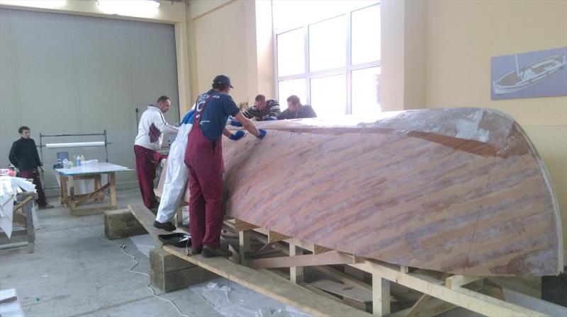 Croatian Gajeta build - the team first roll on a coat of Epoxy onto the bare wooden surface - photo © West System International